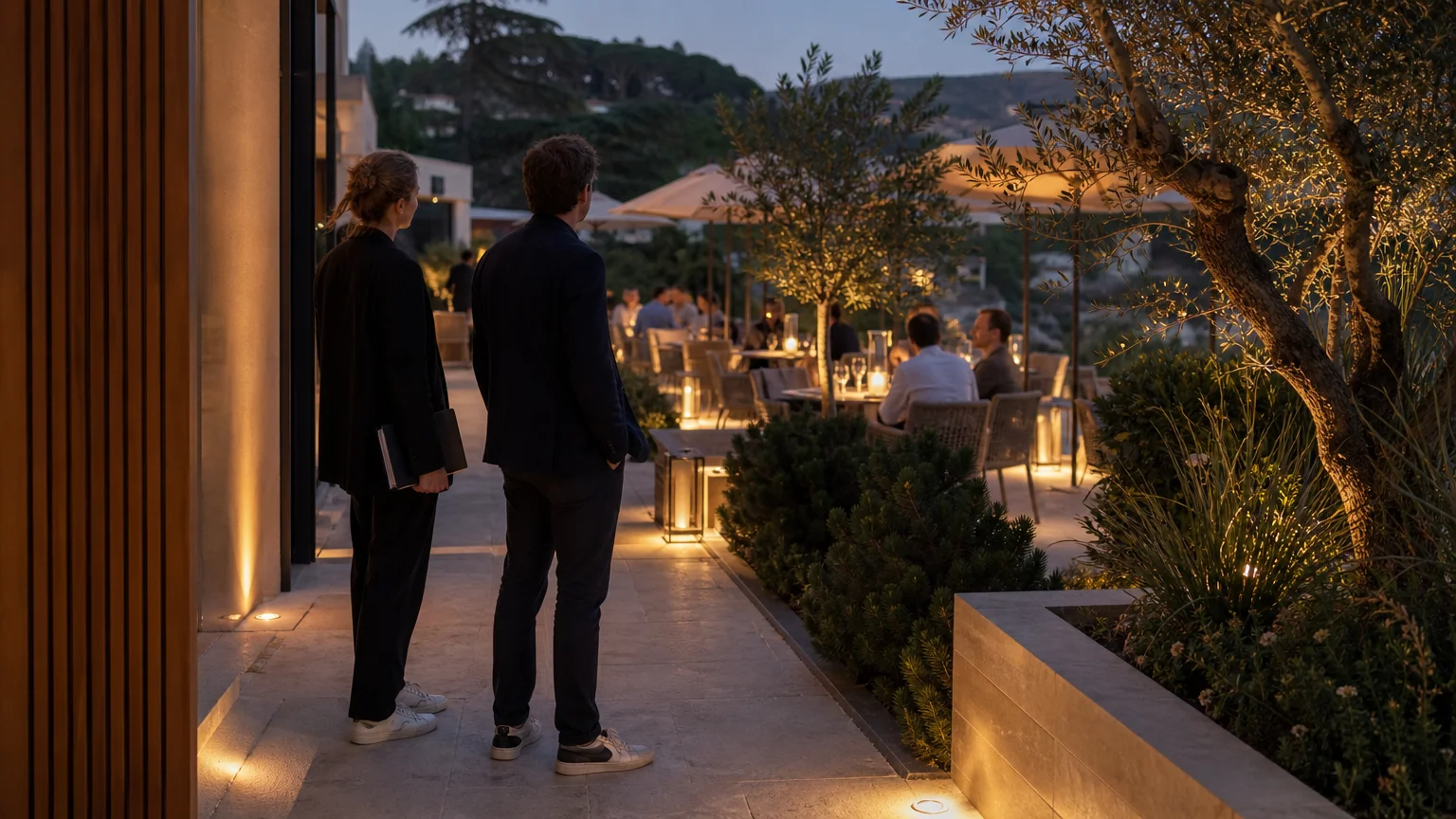 Terrasse d’hôtel éclairée par plusieurs couches de lumière au crépuscule