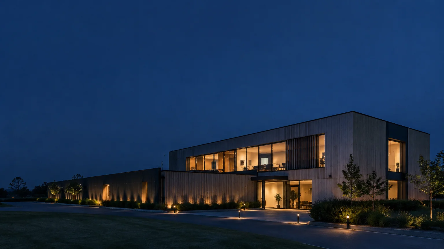 Façade contemporaine éclairée avec sobriété à l’heure bleue